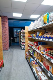 Modern supermarket with well-stocked shelves and light-coloured wooden floor, Tante M, self-service