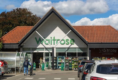 Customers shoppers walking towards entrance doorway of a Waitrose supermarket, Saxmundham, Suffolk,