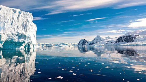Tranquil Arctic landscape with icebergs and mountains under a blue sky, icebergs in the Southern
