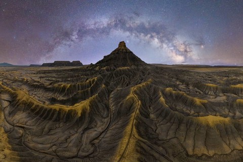 Stunning view of the Milky Way over a sandstone desert in Utah, USA. The sky sparkles with