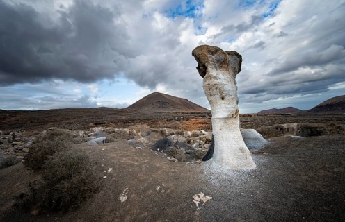 Eroded rock formations, volcanic landscape with dramatic cloudy skies, Ciudad Estratificada or Los