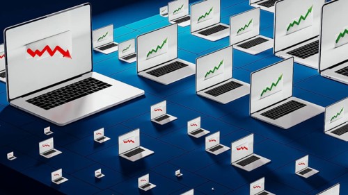 Laptops in a modern office show fluctuating stock trends, reflecting the dynamic nature of