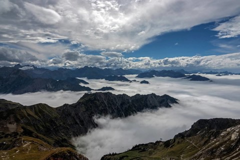 View from the Nebelhorn summit to mountains of the Allgäu Alps, mountains rising from fog in the