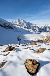 Mountaineer on a hiking trail with snow, descent from Ramoljoch near Spiegelferner, autumnal