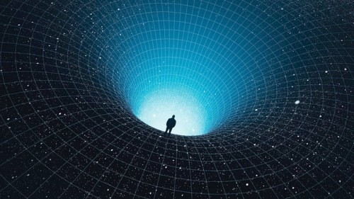 A man stands at the edge of a black hole, gazing into the depths of the universe, surrounded by
