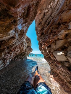 Sitting on the paradise beach of Kroreza or Krorez in a cave on the Albanian riviera in Sarande,