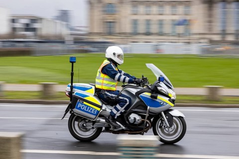 Reichstag Berlin with waving flags. Police motorcycle. Contributor. smudge effect. Berlin, Germany