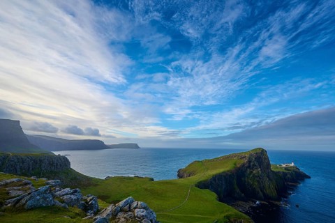 Breathtaking coastal scenery with steep cliffs, blue sky and a secluded lighthouse, Neist Point