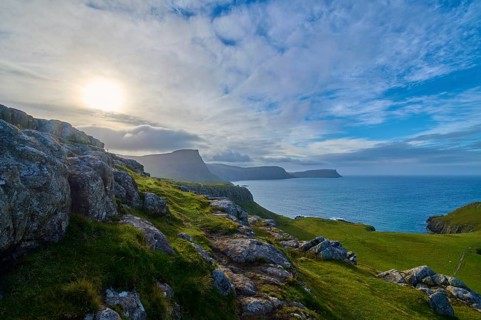Landscape with sunbeams on green cliffs at the blue sea, Waterstein Head, Waterstein, Isle of Skye,