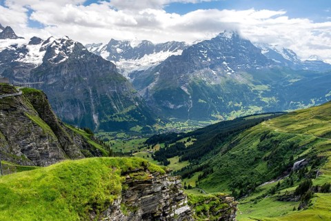 View of mountain landscape with green meadows and alpine huts Bachlager, Grindelwald First,