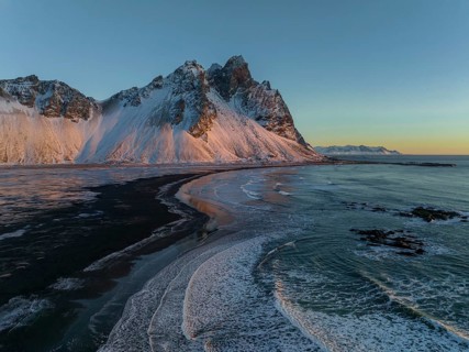 A Stunning view of Stokksnes Mountain, with its snow-covered peaks and the unique black sand beach.