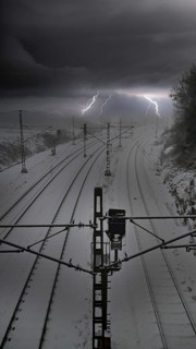 Photo montage of snow-covered train tracks under a dramatic thunderstorm sky with lightning, where