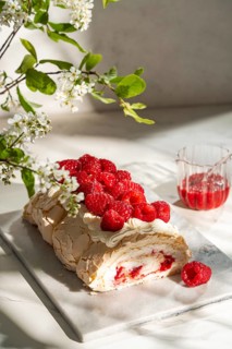 A visually delightful raspberry meringue roulade, featuring a light and airy cream filling, topped