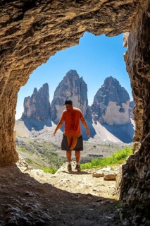 Hiker enjoying the breathtaking view of tre cime di lavaredo, a symbol of the dolomites, from