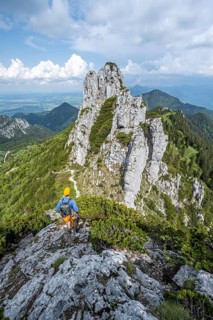 Climber on a climbing tour, on a mountain ridge, behind the summit of the Kampenwand with summit