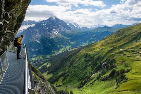 Young man on First Cliff Walk, metal trail on a rocky outcrop, Grindelwald First, in front of
