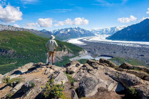 Young man enjoying the view, view of impressive mountain landscape with Matanuska glacier and