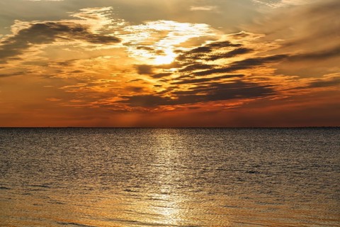 Sunlight glitters golden on the Baltic Sea, evening sky at sunset, Burgsvik, Gotland Island, Sweden
