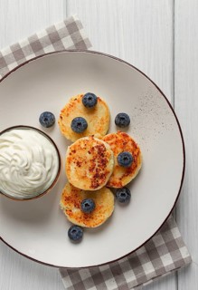 Cottage cheese pancakes, with blueberries, breakfast, on a white wooden table, no people, top view