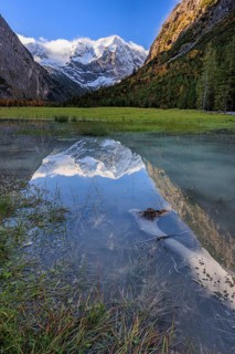 Snow-covered mountains reflected in lake, pond, autumn, Großer Ahornboden, Karwendel Mountains,