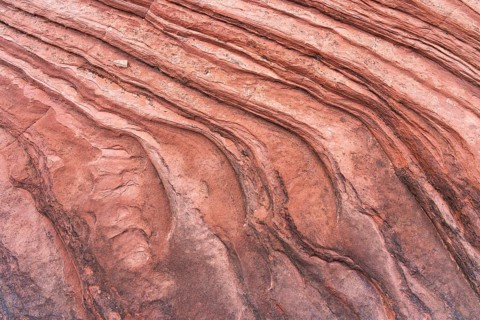 Abstract image showcasing intricate sandstone textures with flowing, undulating patterns. The