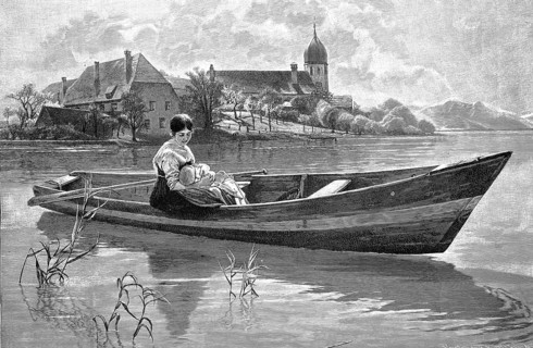Young woman with her baby is on a rowing boat on the lake, in the background a village with church,