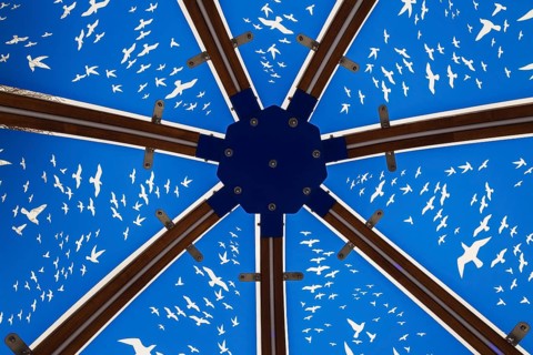 Close-up of backlit blue tinted plexiglass and curved wood panels canopy decorated with white flock