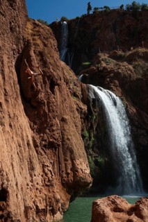 OUZOUD, MOROCCO - OCTOBER 5, 2024: A Moroccan young man jumps from the high rock into the water