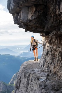 Climbers on a rock band, Bocchette Centrale band trail, via ferrata in the Brenta Mountains,