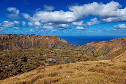 A breathtaking volcanic landscape with crater and ocean views under a blue sky, Ranu Kau volcano on