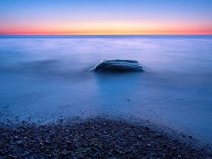 Unspoiled secluded stretch of coast with boulders at sunset on the Baltic Sea beach, near Rerik,