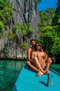Couple kayaking in turquoise waters of twin lagoon, coron island, embraces the stunning rock