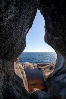 View from a rocky cave over the blue sea in bright sunshine. Summer, Brufjellhålene (Antrum),