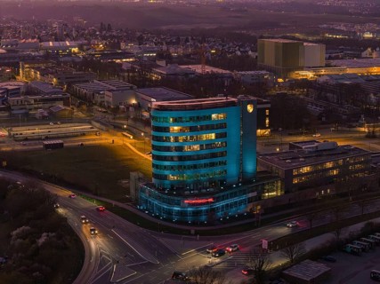 An evening cityscape with an illuminated skyscraper in the center, Porsche, Bietigheim, Germany