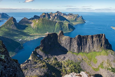 Aerial view from top of Mt. Grytetippen towards village Fjordgard, Mt. Segla and Mt. Hesten, Senja