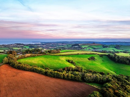 Sunset of Devon Farms and Fields over Berry Pomeroy from a drone, Totnes, England, United Kingdom