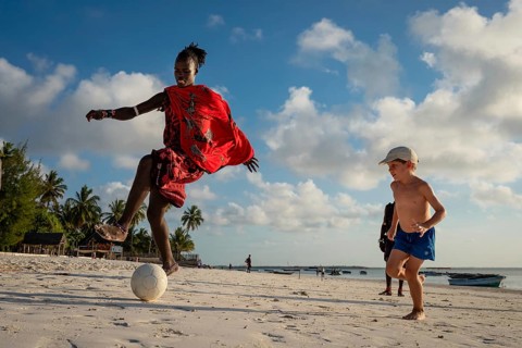 MICHAMVI KAE, ZANZIBAR - OCTOBER 14, 2025: A Maasai warrior in traditional red clothing plays