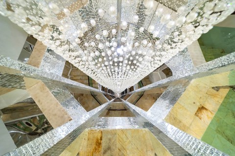 Huge lamp decorated with glass beads in the stairwell, main chedi (Phra That), Buddhist temple