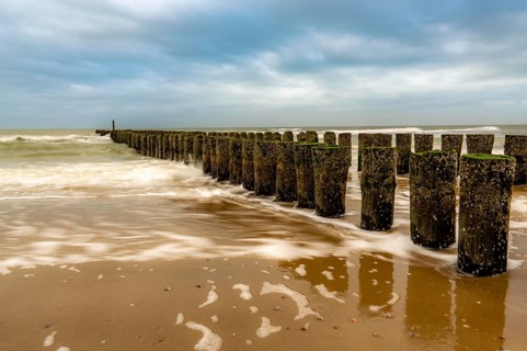 Coastal protection, through wooden posts, paalhoofden, on the beach, breakwater, the piles, some of