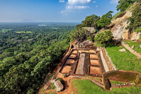 View of old ruins on a rocky plateau with lush forest and wide horizons, The Lion Gate on Lion's