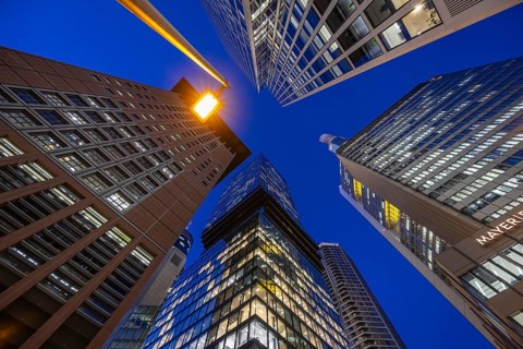 The glowing skyscrapers of Frankfurt's banking skyline rise into the blue evening sky, Frankfurt am