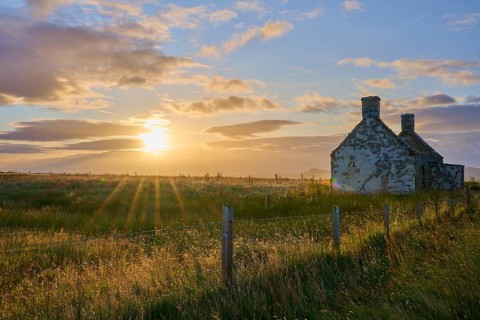 Rural old house in a meadow at sunrise with clouds in the sky, Moine House, Lairg, Scotland, United