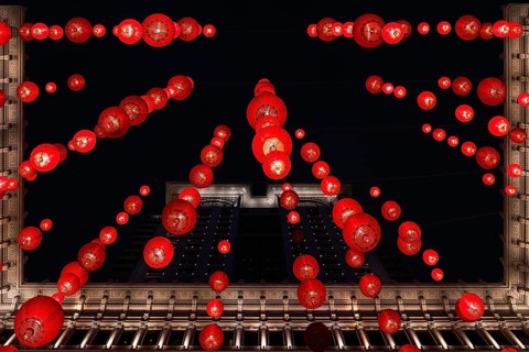From below a festive red lanterns adorn a classical building in Hong Kong, brilliantly lit against