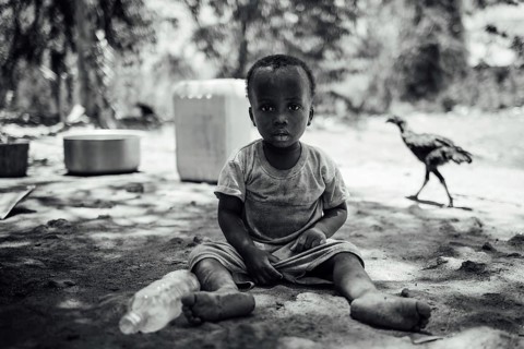 MICHAMVI KAE, ZANZIBAR - OCTOBER 17, 2025: A monochrome portrait of a young child sitting on the