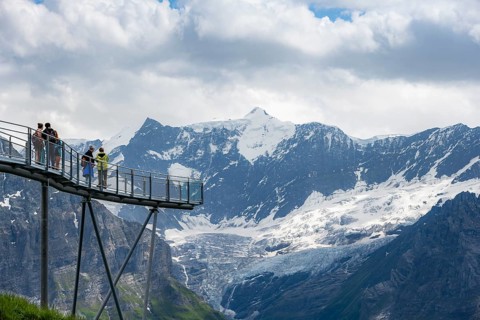 Tourists on First Cliff Walk, metal trail on a rocky outcrop, Grindelwald First, in front of