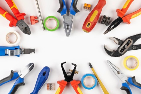 Various tools and adhesive tape arranged in a circle around a white background