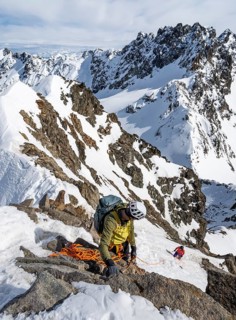 Mountaineer belaying on a steep snow slope, belaying on a rope, ascent to the summit of Piz