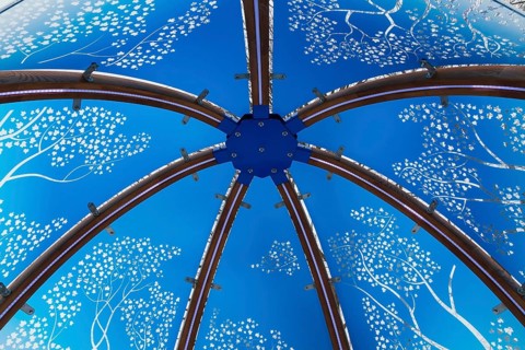 Close-up of backlit blue tinted plexiglass and curved wood panels canopy decorated with white maple