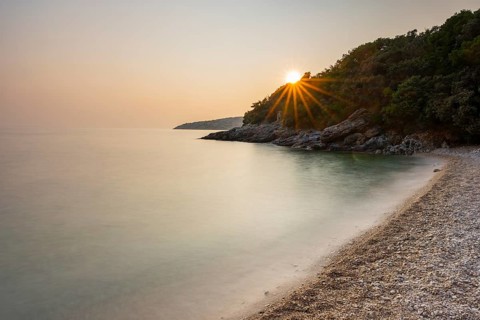 Crystal clear and turquoise water on the beach of Ustrine Bay on a sunny day at sunset on the