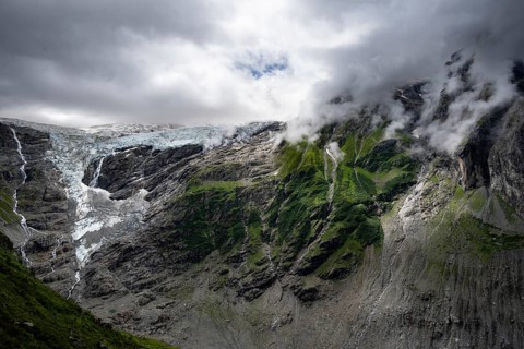 Dramatic mountain landscape covered in clouds with Grindelwald-Fiescherfirn glacier, Bernese Alps,